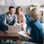 speaking with a residential real estate agent holding a clipboard