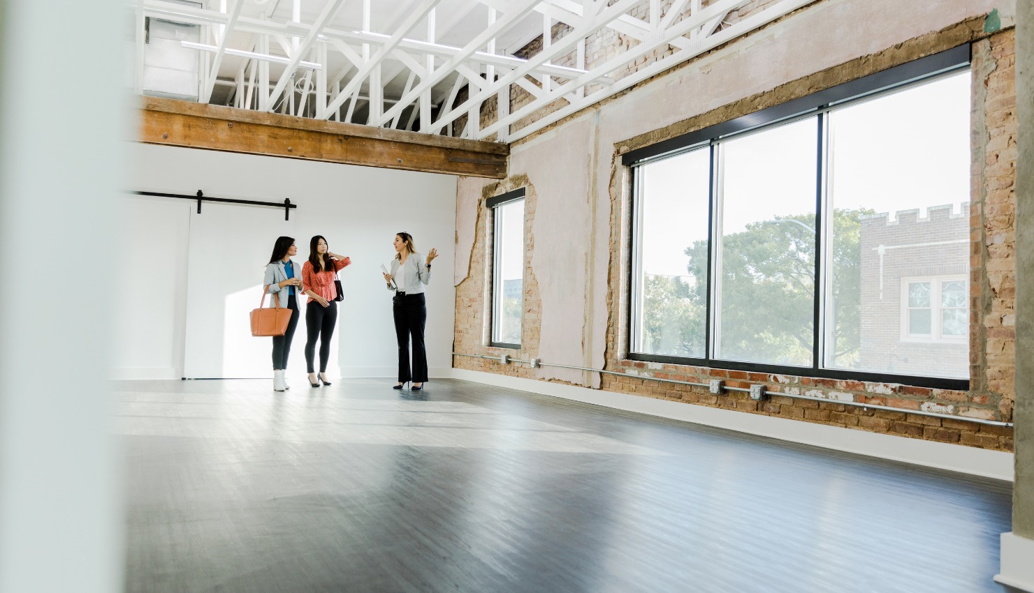 A real estate agent shows a vacant industrial-style commercial lease space